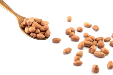 Peanuts in a wooden spoon And some are scattered  isolated on a white background