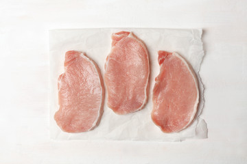 Pieces of pork loin. Raw meat on parchment.On white background. BBQ