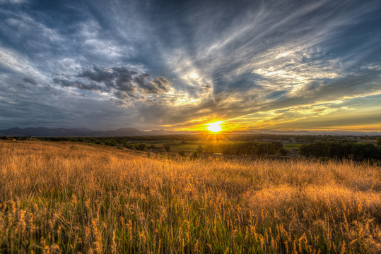 Crisp clouds over boulder at sunset