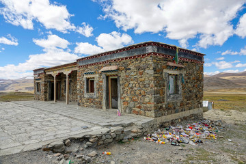 CLOSE UP: Garbage starts piling up next to an abandoned stone house in Tibet.