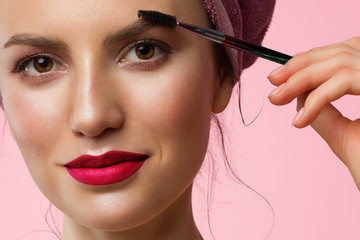 Close-up of a beautiful woman with natural make-up and clean skin with a towel on her head. Pink...