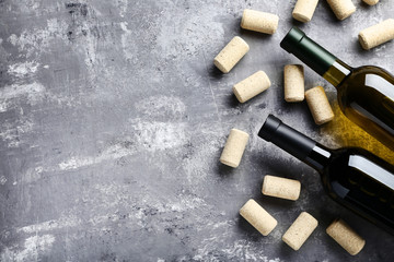 Wine bottles with corks on grey wooden table