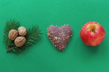 green Christmas border with gingerbread heart, walnuts and apple
