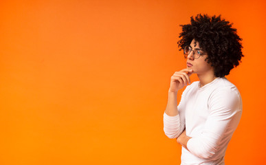 Thoughtful black man profile portrait on orange background
