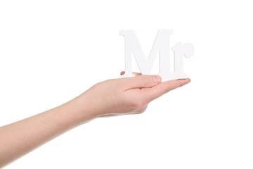Female hand holding letters Mr on white background