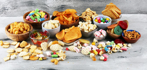Salty snacks. Pretzels, chips, crackers and candy sweets on table - obrazy, fototapety, plakaty