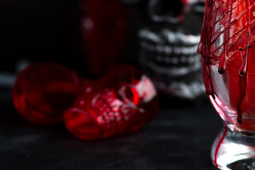 Halloween bloody glass with a human skeleton face as cup on black background