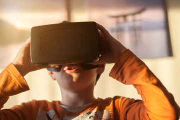 boy playes with modern virtual reality glasses