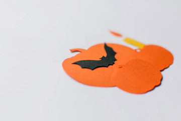 Halloween decorations with paper pumpkins, bats, candles on white background. Halloween and decoration concept. Flat lay, top view, copy space