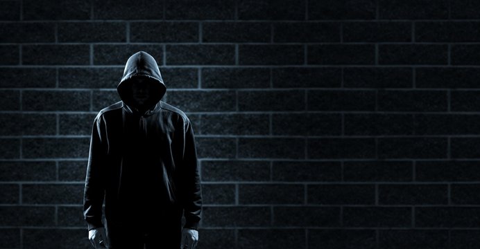 Thief in black clothes on grey background