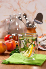 Refreshing drink with lemon and mint in a glass cup