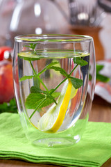 Refreshing drink with lemon and mint in a glass cup