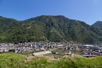 Fototapeta na wymiar panoramic of small town surrounded by mountains - landscape of latino america Guatemala