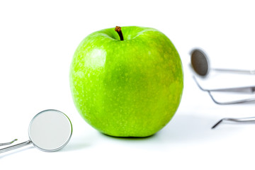 dental tools with apple on white background