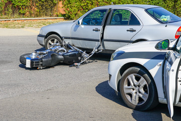 traffic accident, motorcycle collision with a car on city street