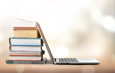 Stack of books with laptop