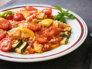 Plate with a home made zucchini and tomato risotto.