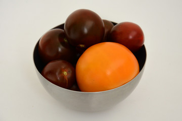 dark and yellow tomatoes in a bowl