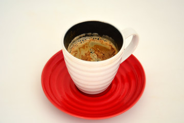 Cup of black coffee with foam in white cup on red concrete background, sunlight. Cafe, break concept. Top view, flat lay, copy space, layout design