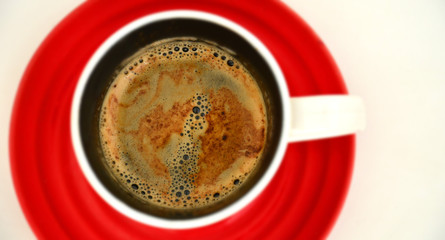 Cup of black coffee with foam in white cup on red concrete background, sunlight. Cafe, break concept. Top view, flat lay, copy space, layout design