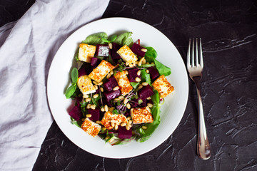 beetroot salad with grilled cheese and pine nuts, top view