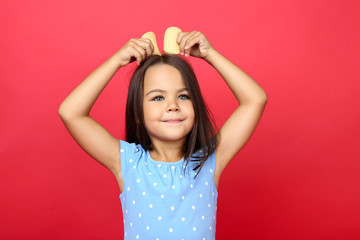 Beautiful little girl with potato chips on red background