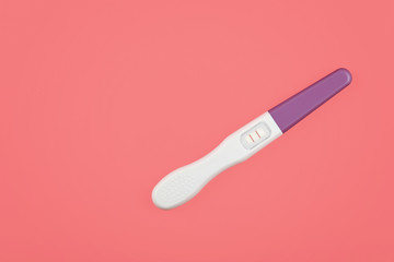 Close up positive pregnancy test over pink