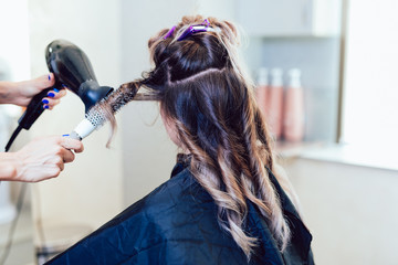 Fototapeta premium Young woman getting beautiful hairstyle in hair salon.