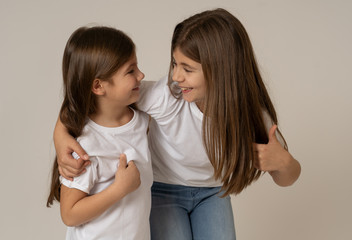 two cute sisters playing together having fun posing and modeling