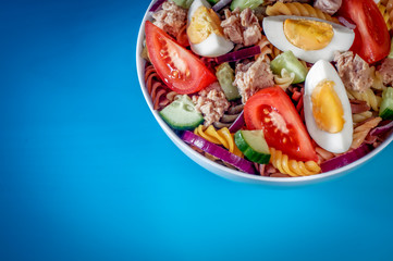 Tuna salad. Blurred blue background. Selective focus. Free space.