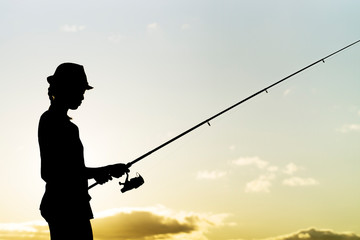 angler fisherman girl with rod and reel catch fishes in tropical sea