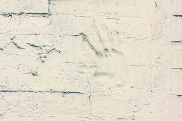 part of the wall covered in white paint with a palm dent in it