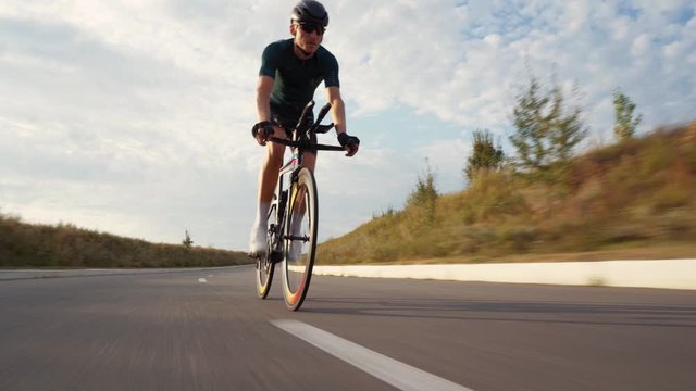 Sports athlete man biking with high intensity on highway