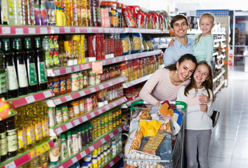 Positive  customers with children buying food in hypermarket