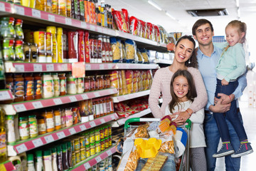 Charming customers with children buying food in hypermarket