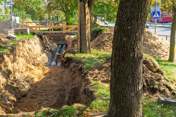 Fototapeta premium Repair of city water supply. New modern technologies of urban engineering networks. City Water Pipeline. Saving trees.