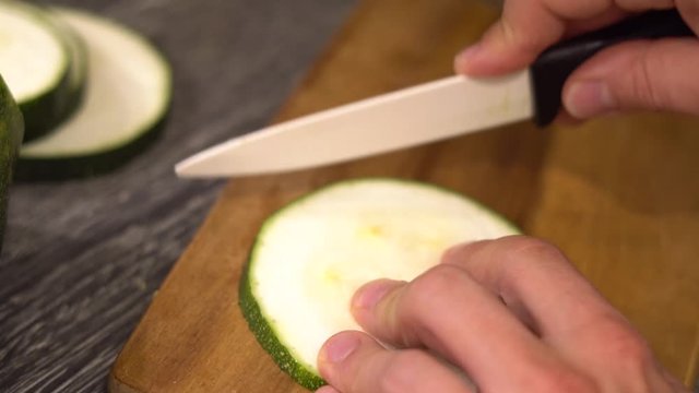 Zucchini wir in schmale Streifen geschnitten, auf einem Holzbrett