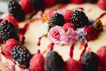 blackberries and raspberries and flowers on cheese cake 