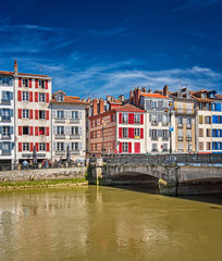 Fototapeta na wymiar Colorful houses at the Nive river embankment in Bayonne, France