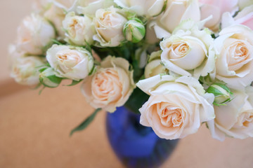 A bouquet of fresh tea and gently pink roses on a beige background.