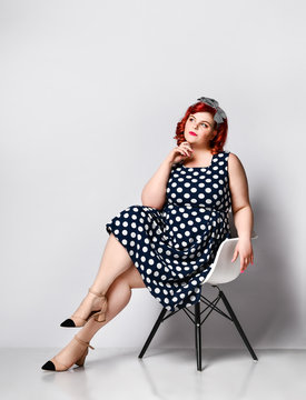 Pin up a female portrait. Beautiful retro fat woman in polka dot dress with red lips and old-style haircut