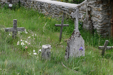Crosses between the grass of a poor village cemetery