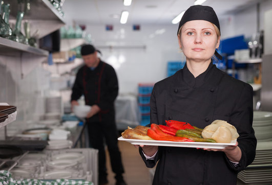 Female chef with cooked dish