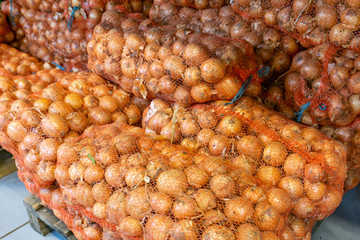 Onions in nets in a supermarket on a store counter for sale
