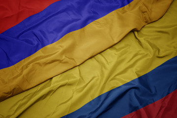 waving colorful flag of colombia and national flag of armenia.