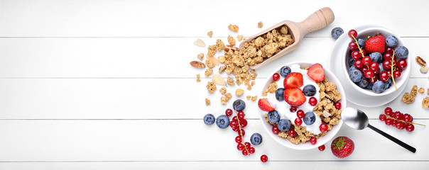 Breakfast with yogurt, muesli and berries on white wood background, top view, space for text. - obrazy, fototapety, plakaty