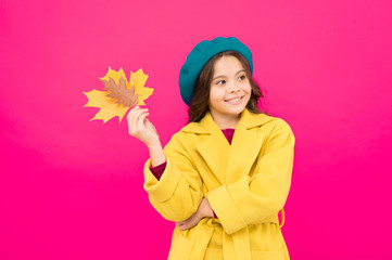 Climate changes. Autumn is here. Small girl fall outfit red background. Hello october. Little girl welcome autumn. Kid girl cute face hold maple leaf. Enjoy season. Child with autumn yellow leaf