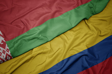 waving colorful flag of colombia and national flag of belarus.