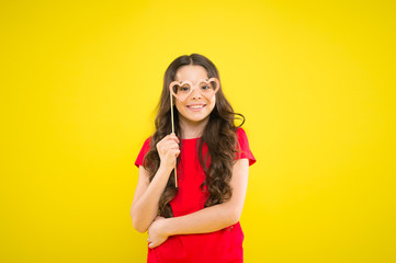 Having real fun. prepare for party. happy girl at yellow wall. summer fashion. small girl with party glasses. small girl hold funny glasses. happy birthday. party elements. child ready for party