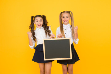 Giving information. Little kids making yes gesture with blank blackboard for information on yellow...